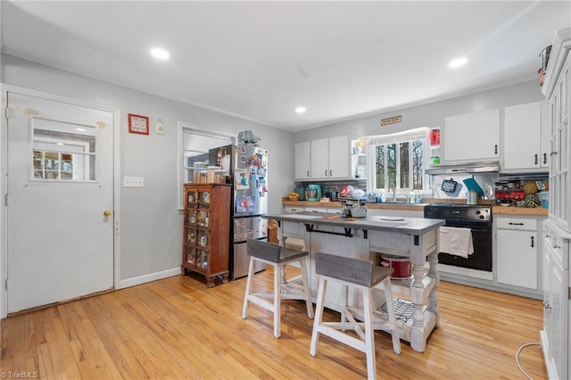 kitchen with a kitchen island, range, white cabinets, and a kitchen breakfast bar