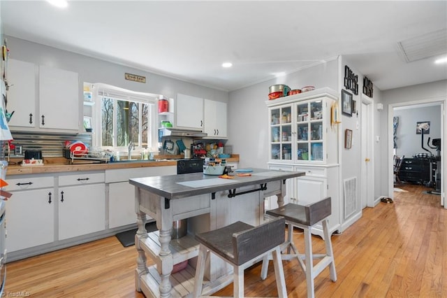 kitchen featuring sink, white cabinets, and light wood-type flooring