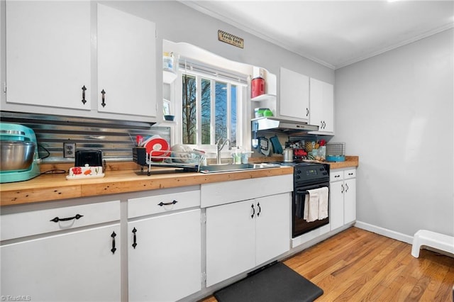 kitchen with black electric range oven, sink, light wood-type flooring, ornamental molding, and white cabinets