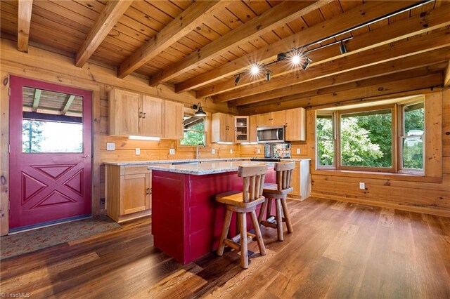 kitchen with stainless steel microwave, dark wood-style flooring, wood ceiling, wood walls, and a center island