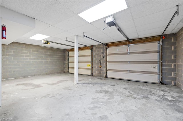 garage featuring a garage door opener and concrete block wall