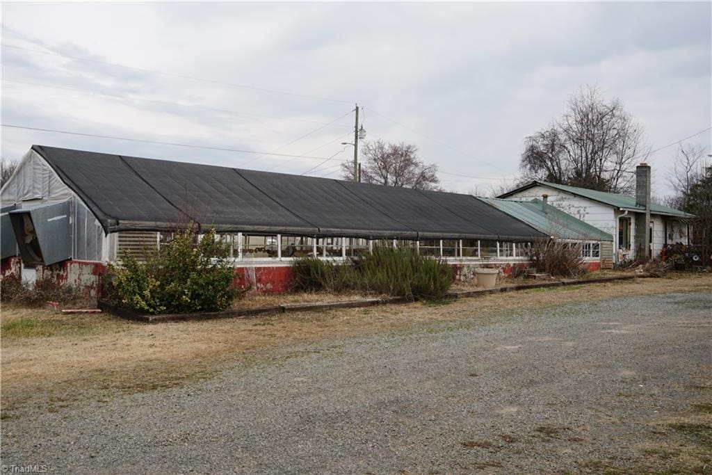 view of front facade with an outbuilding and driveway