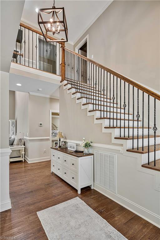 128 Provence Ct, King, NC 27021 - stairs with wood finished floors, crown molding, a towering ceiling, and a chandelier