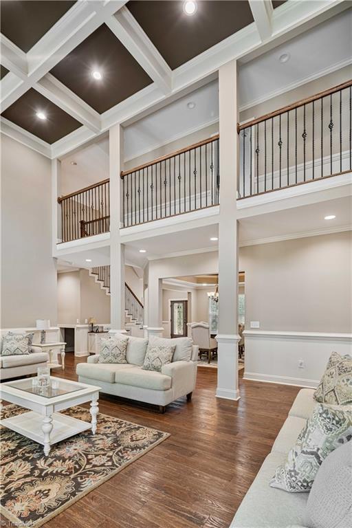 128 Provence Ct, King, NC 27021 - living room with wood finished floors, stairway, ornate columns, a towering ceiling, and crown molding
