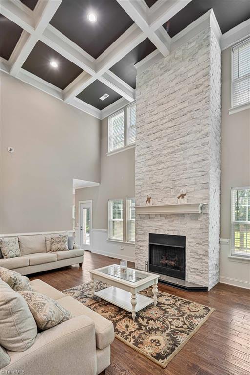 128 Provence Ct, King, NC 27021 - living room with hardwood / wood-style flooring, a towering ceiling, a stone fireplace, beamed ceiling, and coffered ceiling