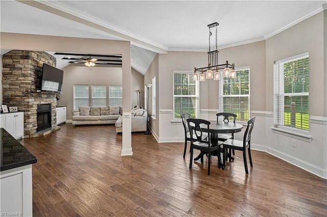 128 Provence Ct, King, NC 27021 - dining space featuring a fireplace, vaulted ceiling, dark wood-style floors, ceiling fan, and a chandelier