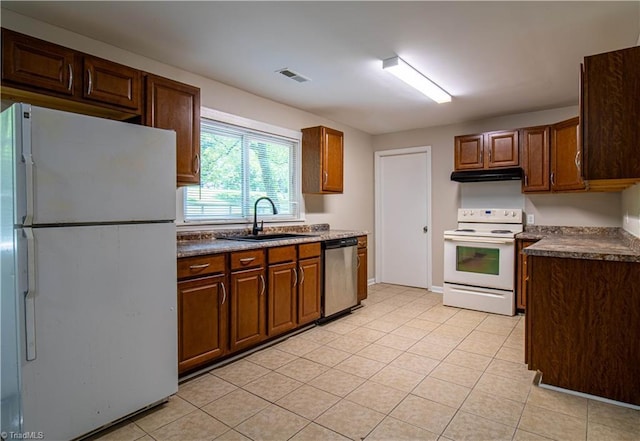 2370 W Clemmonsville Rd, Winston-Salem, NC 27127 - kitchen featuring white appliances, a sink, light tile patterned floors, under cabinet range hood, and dark countertops