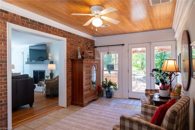 living area with light tile patterned flooring, brick wall, wood ceiling, and ornamental molding