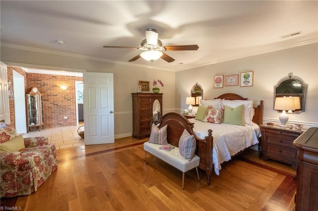 bedroom with a ceiling fan, crown molding, light wood-style floors, and visible vents