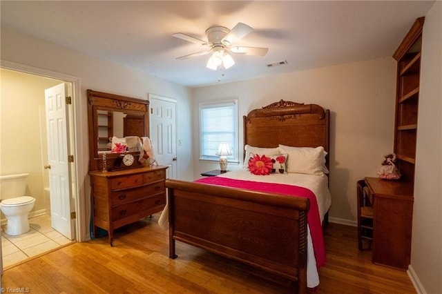 bedroom with visible vents, wood finished floors, connected bathroom, baseboards, and ceiling fan