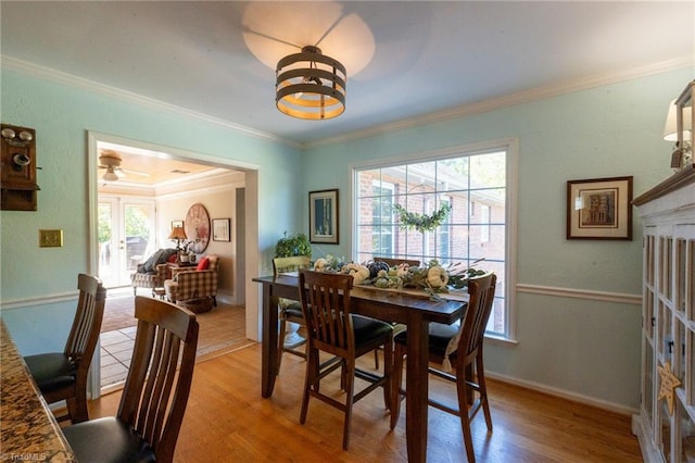 dining area featuring crown molding, baseboards, and wood finished floors