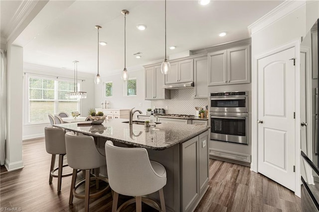 1348 Motsinger Rd, Winston-Salem, NC 27107 - kitchen featuring gray cabinets, a kitchen bar, appliances with stainless steel finishes, a sink, and under cabinet range hood