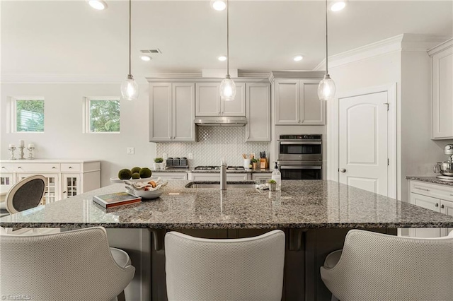 1348 Motsinger Rd, Winston-Salem, NC 27107 - kitchen featuring a breakfast bar area, backsplash, visible vents, double oven, and under cabinet range hood