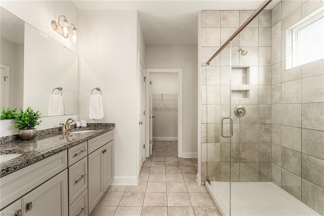 1348 Motsinger Rd, Winston-Salem, NC 27107 - bathroom with a walk in closet, a sink, double vanity, tile patterned floors, and a stall shower