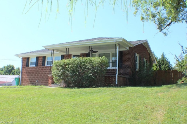 view of front of home with a front yard and ceiling fan