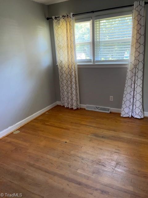 unfurnished room featuring hardwood / wood-style flooring and plenty of natural light