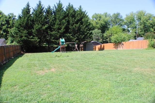 view of yard with a storage unit and a playground