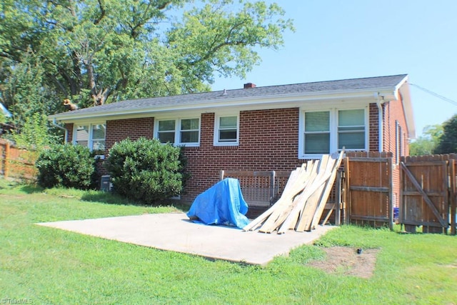 back of property with a yard and a patio