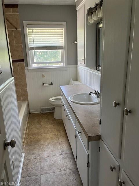 full bathroom with tile patterned flooring, vanity, toilet, and tiled shower / bath combo