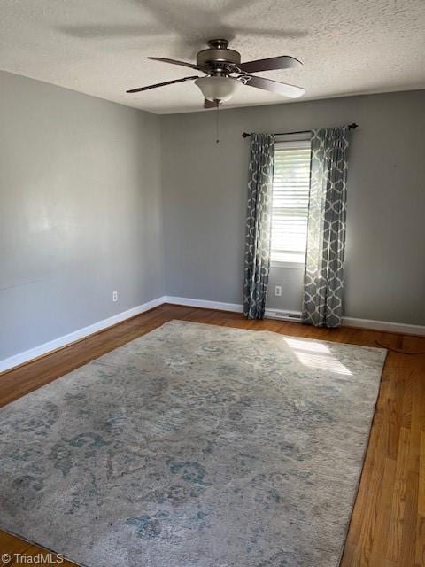 spare room featuring ceiling fan, wood-type flooring, and a textured ceiling