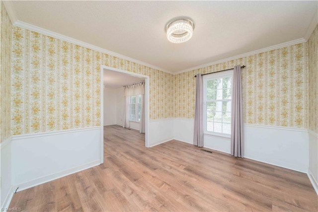 3306 Midkiff Rd, Winston-Salem, NC 27106 - spare room with wainscoting, ornamental molding, wood finished floors, wallpapered walls, and a chandelier