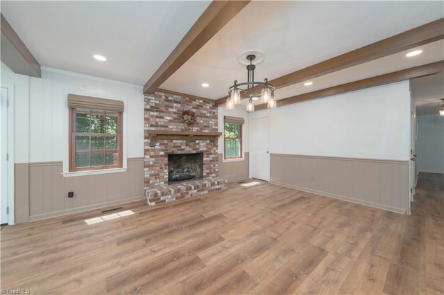 3306 Midkiff Rd, Winston-Salem, NC 27106 - unfurnished living room with beamed ceiling, wood finished floors, a chandelier, a fireplace, and a wainscoted wall