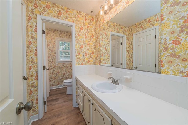 3306 Midkiff Rd, Winston-Salem, NC 27106 - bathroom featuring wood finished floors, vanity, wallpapered walls, and toilet
