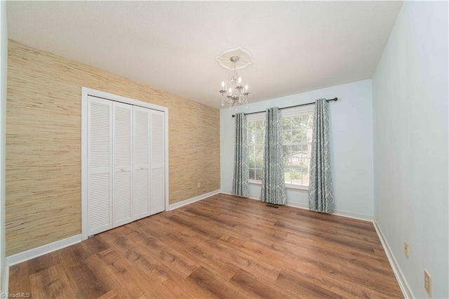 3306 Midkiff Rd, Winston-Salem, NC 27106 - unfurnished bedroom featuring a chandelier, baseboards, wood finished floors, and a closet