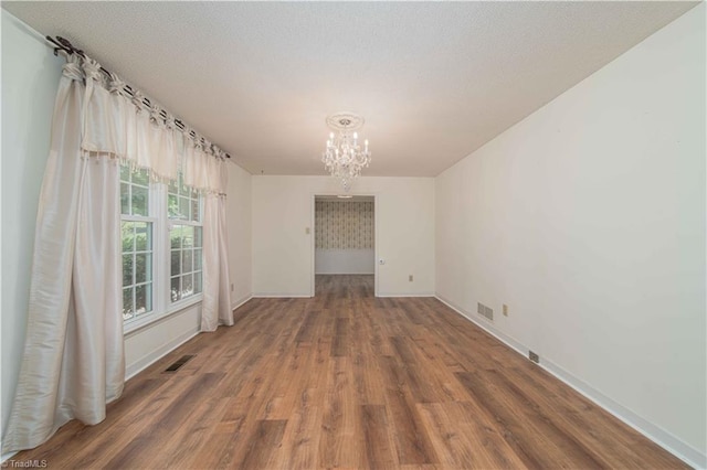 3306 Midkiff Rd, Winston-Salem, NC 27106 - spare room with a chandelier, wood finished floors, and baseboards