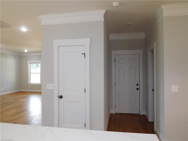 hallway with crown molding, recessed lighting, wood finished floors, and baseboards