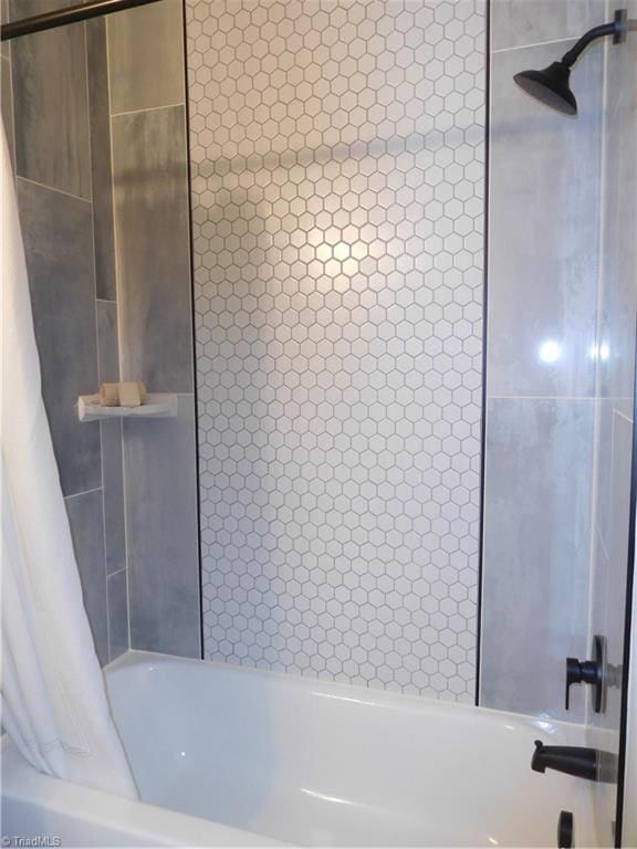 bathroom with shower / bath combo with shower curtain