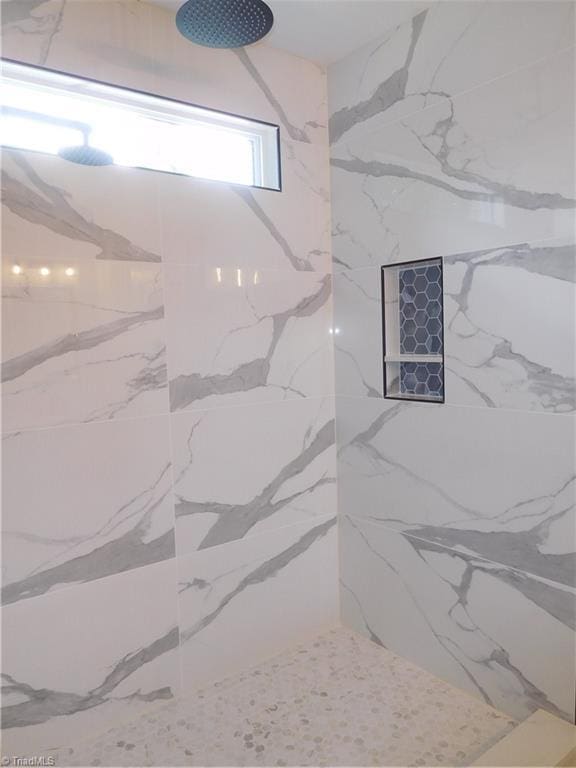 bathroom featuring a marble finish shower