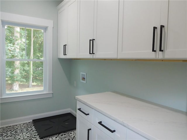 laundry room featuring baseboards, cabinet space, a healthy amount of sunlight, and hookup for a washing machine