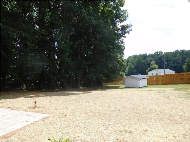 view of yard with an outdoor structure, a storage unit, and fence