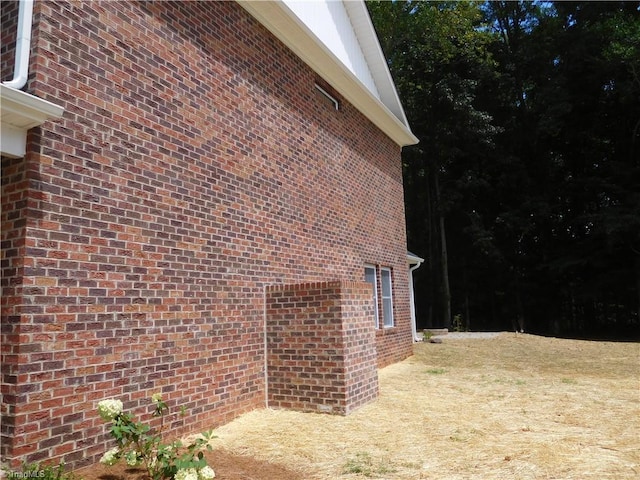 view of side of home with brick siding