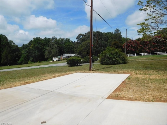 exterior space featuring a lawn, a wooded view, and fence