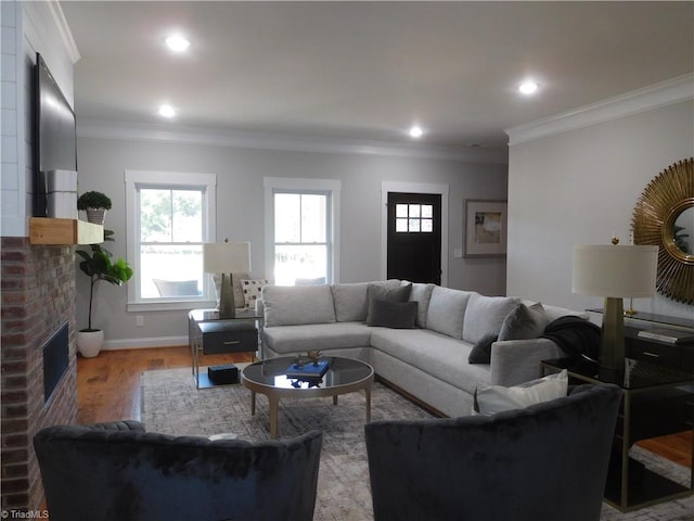 living room with recessed lighting, wood finished floors, a fireplace, and ornamental molding