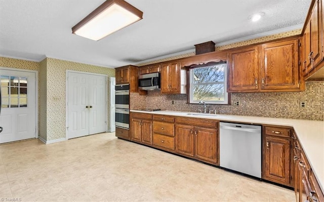 kitchen featuring stainless steel appliances, tasteful backsplash, crown molding, and sink