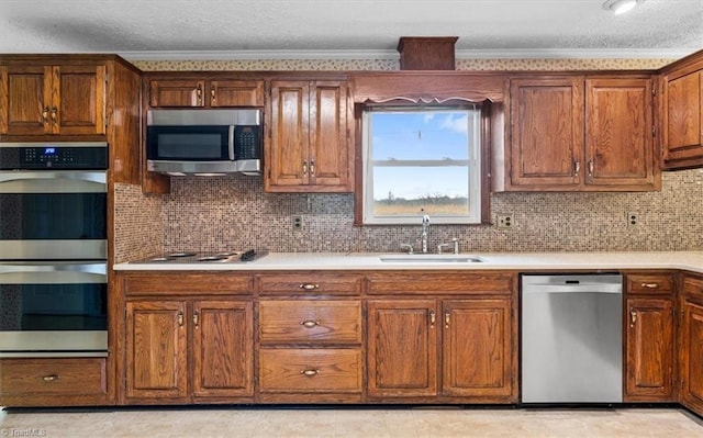 kitchen with appliances with stainless steel finishes, tasteful backsplash, crown molding, and sink