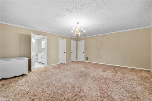 carpeted spare room featuring crown molding, a textured ceiling, and an inviting chandelier