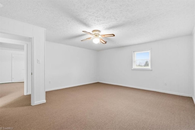 carpeted empty room featuring ceiling fan and a textured ceiling