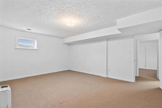 basement with light colored carpet and a textured ceiling