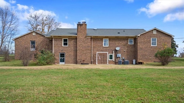 rear view of house with a yard and cooling unit