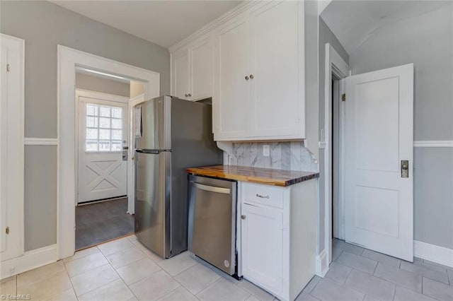 kitchen with white cabinets, wooden counters, appliances with stainless steel finishes, and light tile patterned floors