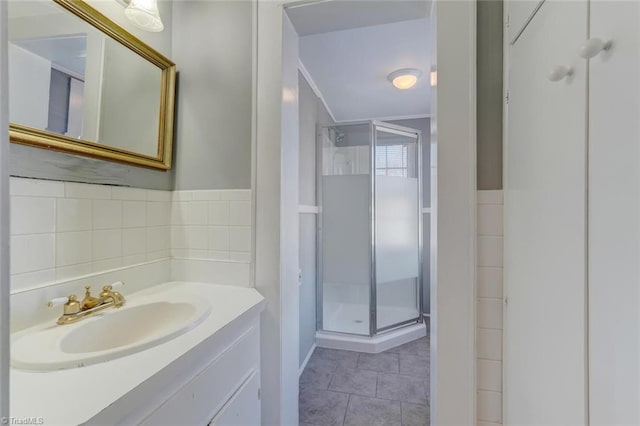 bathroom featuring tile walls, tile patterned flooring, vanity, crown molding, and walk in shower