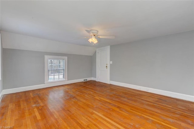 spare room featuring ceiling fan, light hardwood / wood-style floors, and lofted ceiling