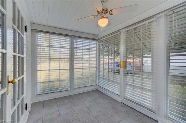 unfurnished sunroom featuring ceiling fan