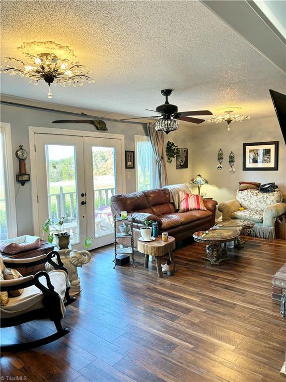 living room with a textured ceiling, french doors, hardwood / wood-style flooring, and ceiling fan