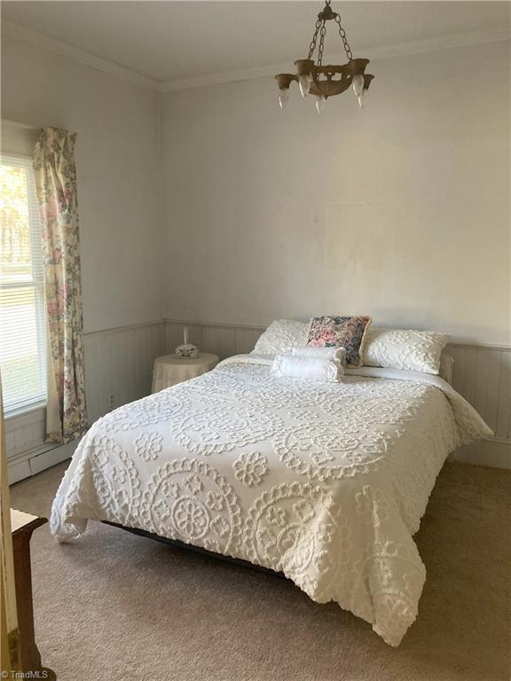 bedroom with crown molding, carpet floors, and a notable chandelier