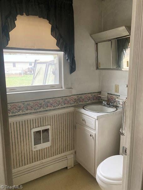 bathroom featuring vanity, radiator, and toilet